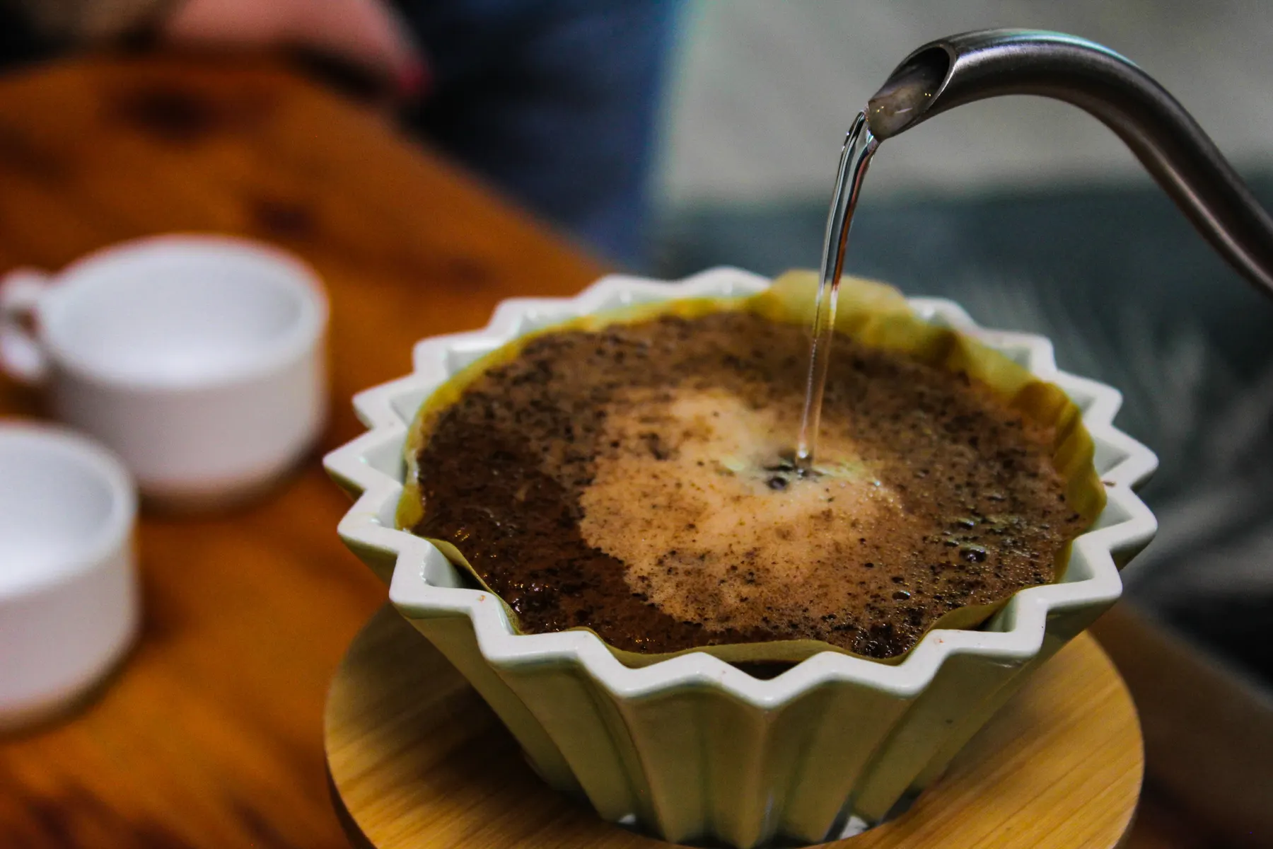 Vertiendo agua caliente sobre el café en un filtro de cerámica